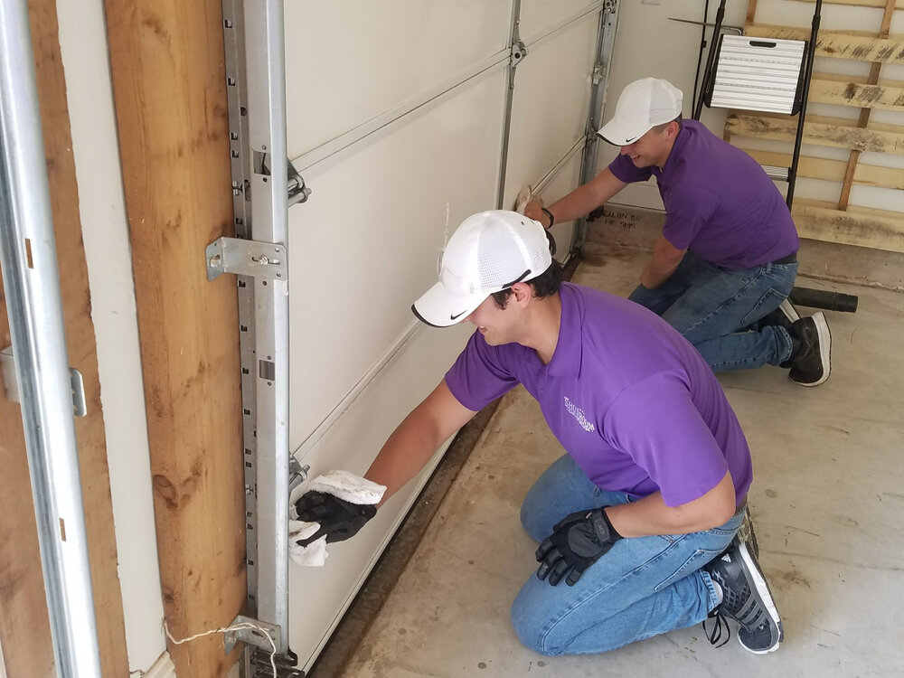 Photo of Jordo and Cole cleaning a garage door.